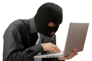 Masked burglar in front of a laptop