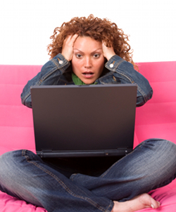 Woman sitting in front of laptop, looking stressed and overwhelmed