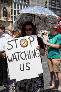 woman-holding-stop-watching-us-sign