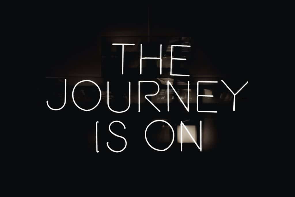 Neon sign that says "The Journey Is On"